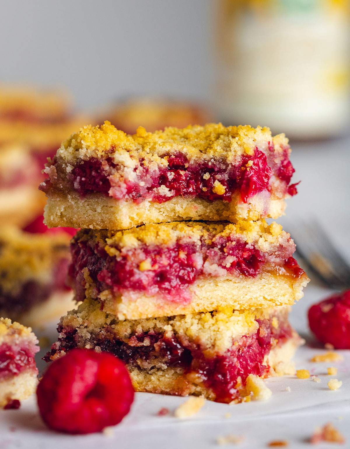 A stack of three butterscotch crumble bars are sitting on top of each other and there is a bite taken out of the one on top.