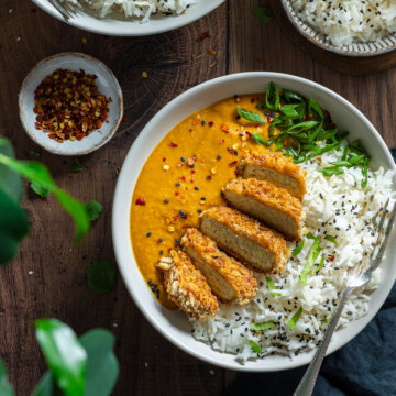 Vegan Katsu Curry with Tempeh - two bowls on a dark wooden table top, with a fork in each bowl