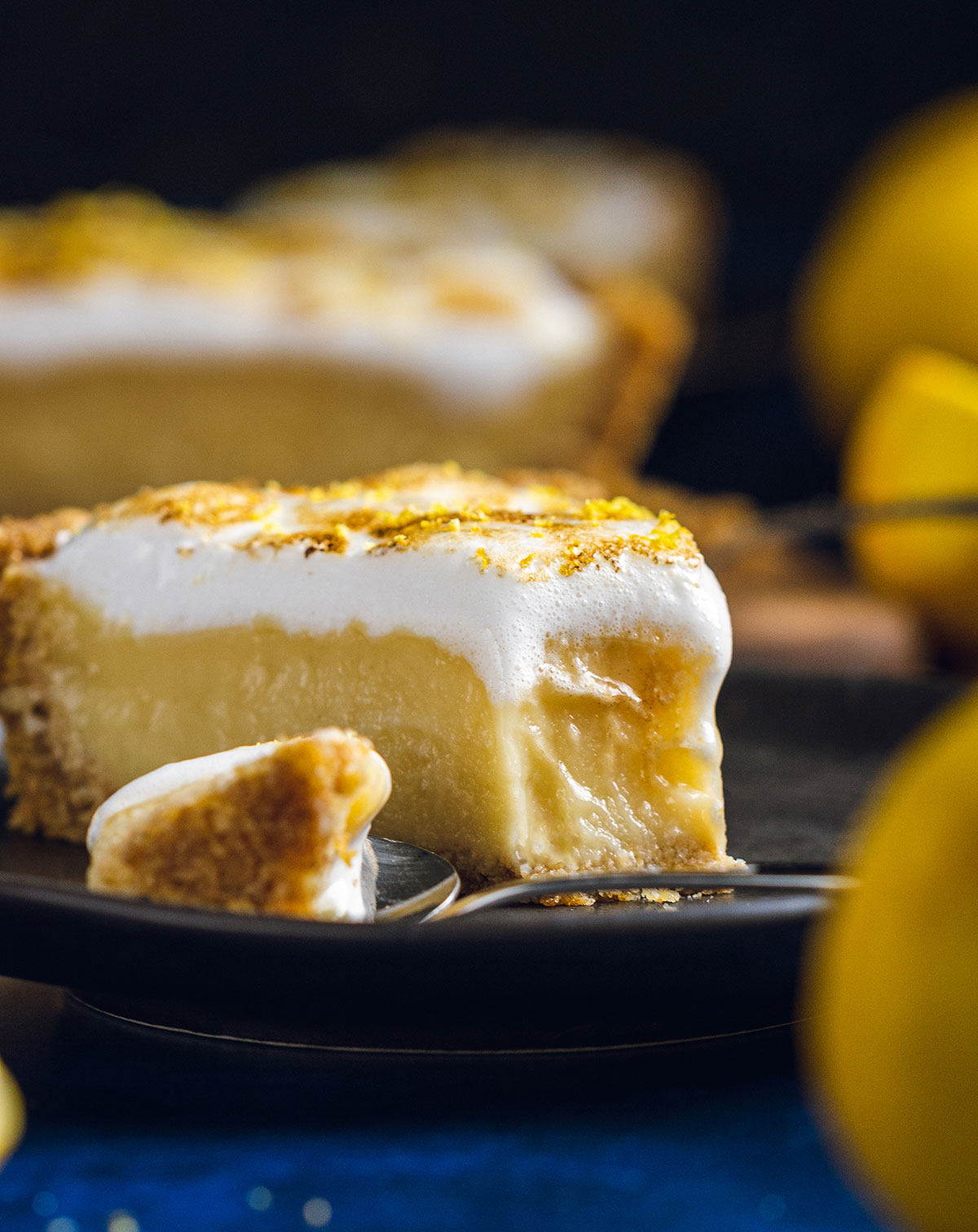 a slice of lemon meringue pie with a bite taken out of it