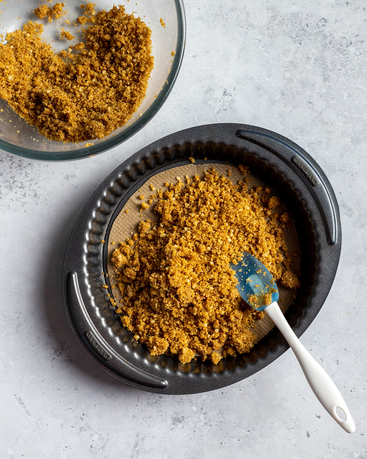 biscuit crumble added into a pie tin