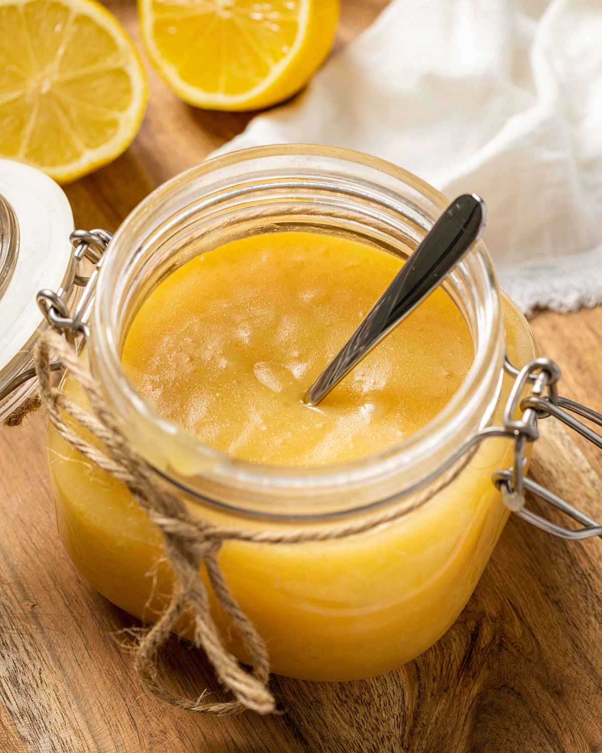 lemon curd without eggs in a jar with a spoon in it