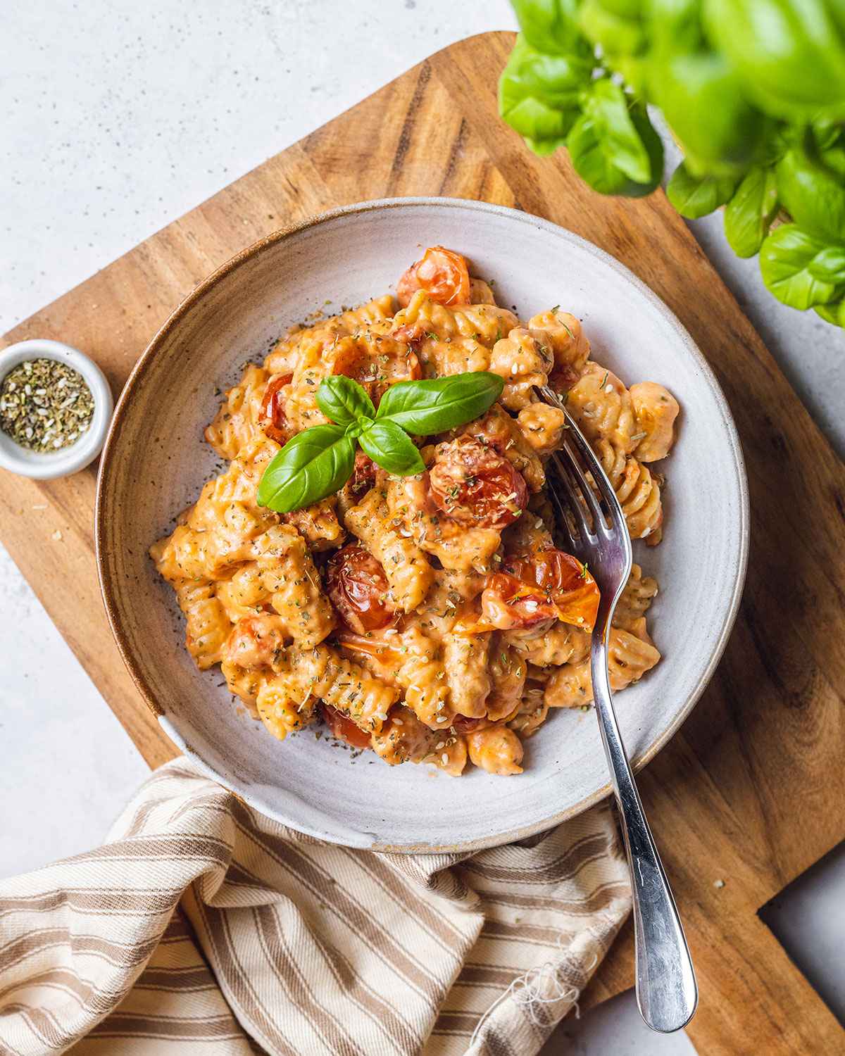 Baked Boursin pasta in a bowl ready to serve with basil on top.