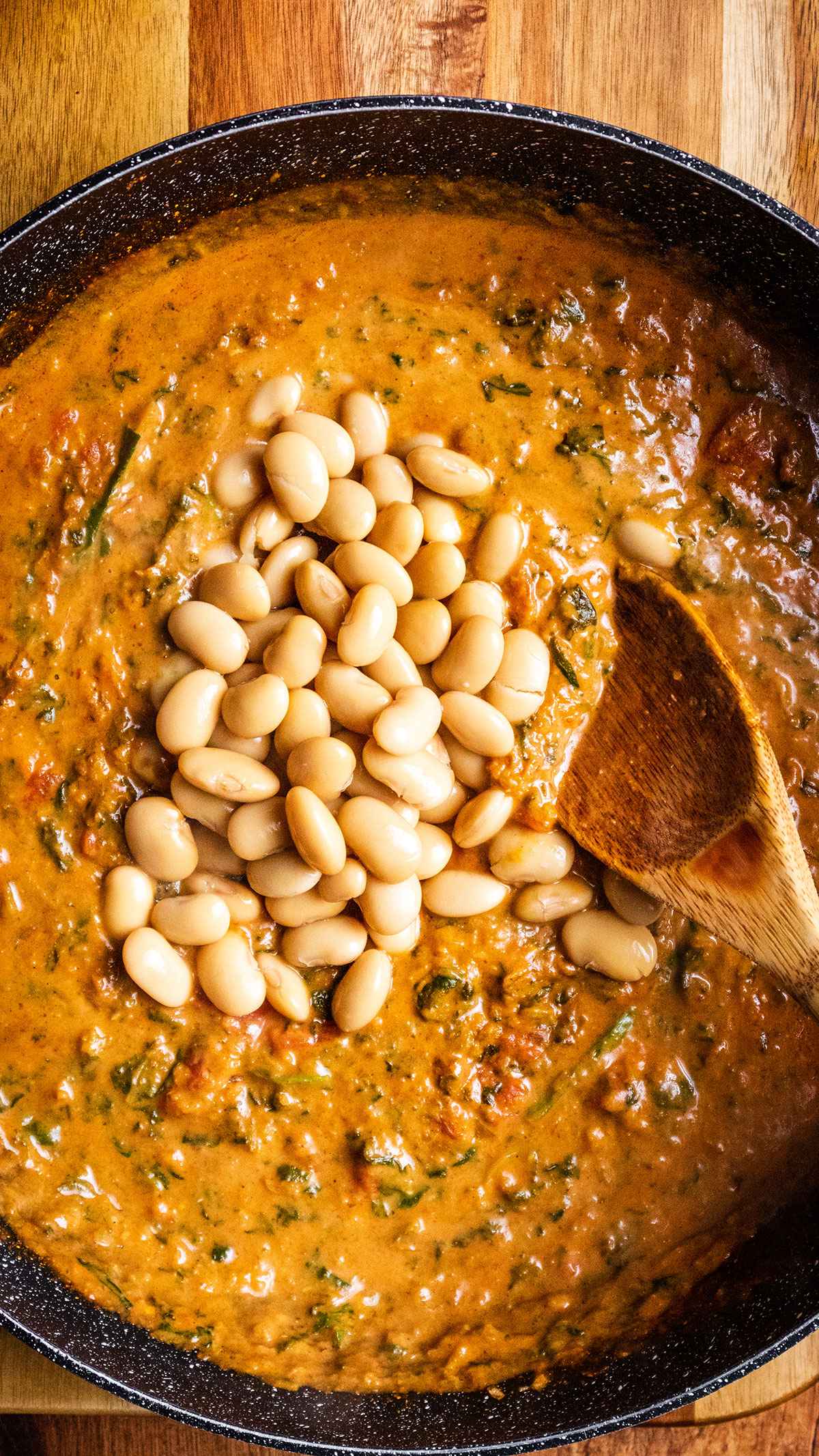 Butter beans are added to the skillet.