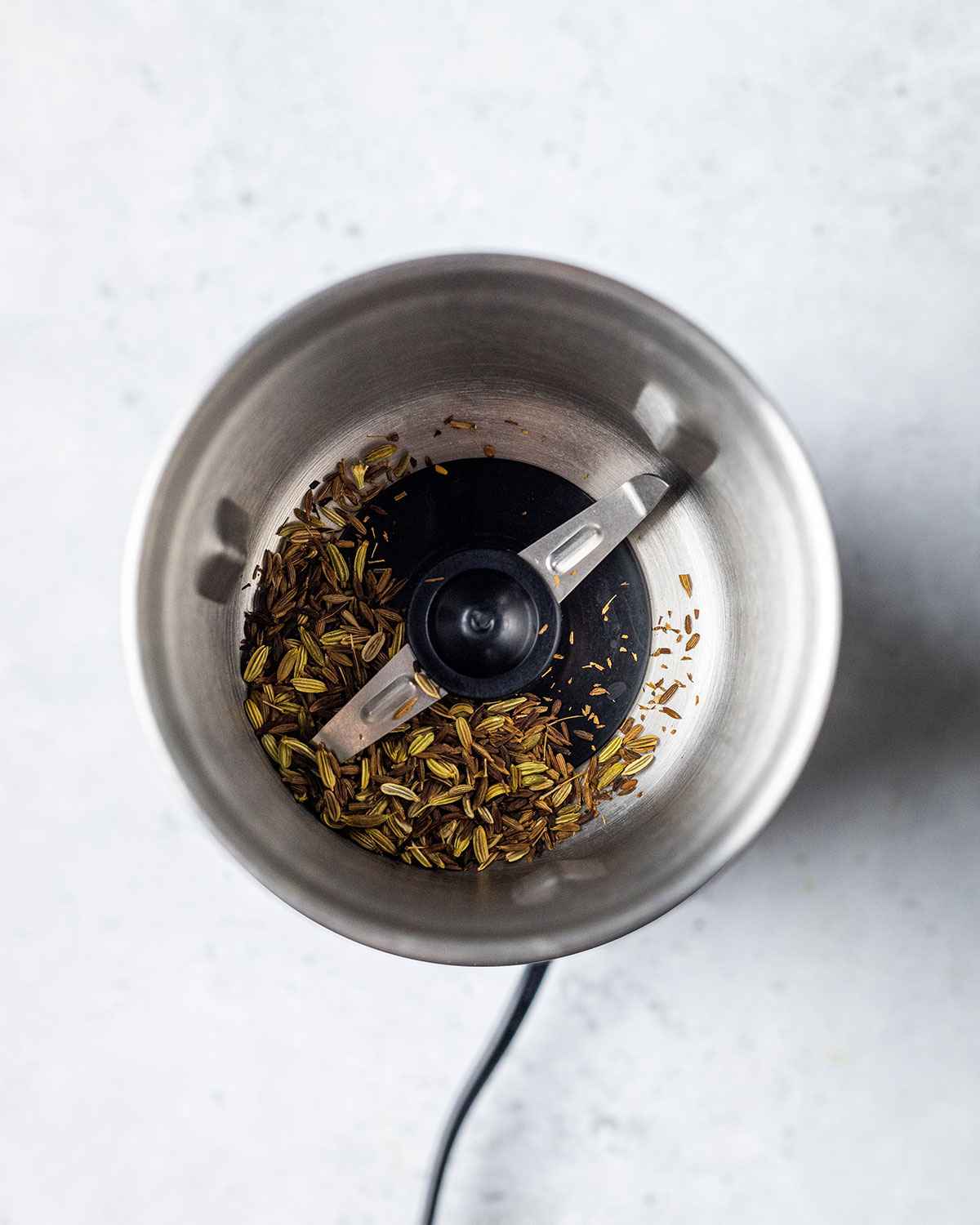 toasted fennel and cumin seeds in a spice grinder