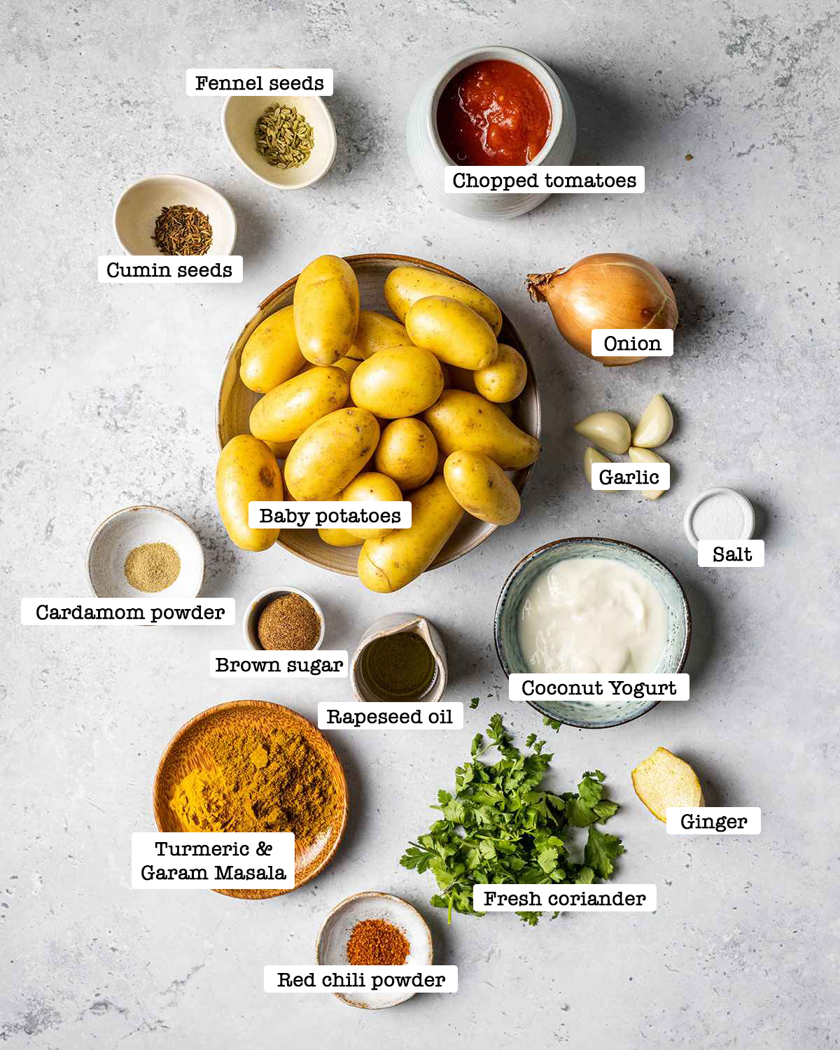 ingredients for making a vegan dum aloo recipe on a white marble table