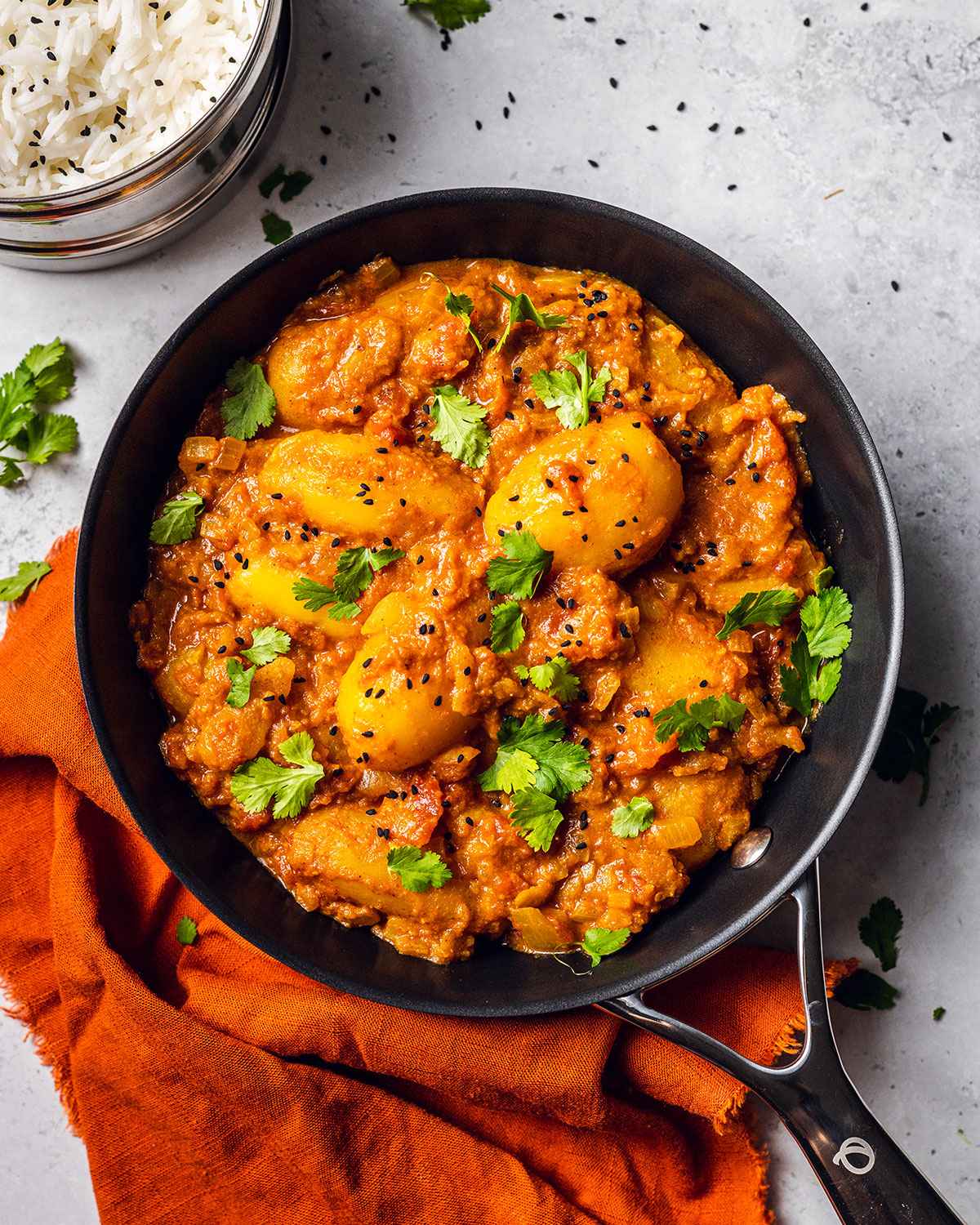 Potato curry in a pan on marble table