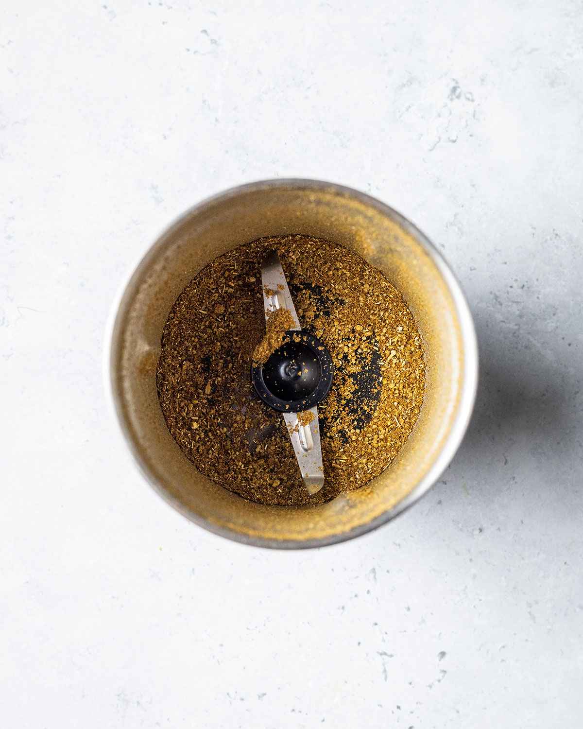 ground fennel seeds and cumin seeds in a spice grinder