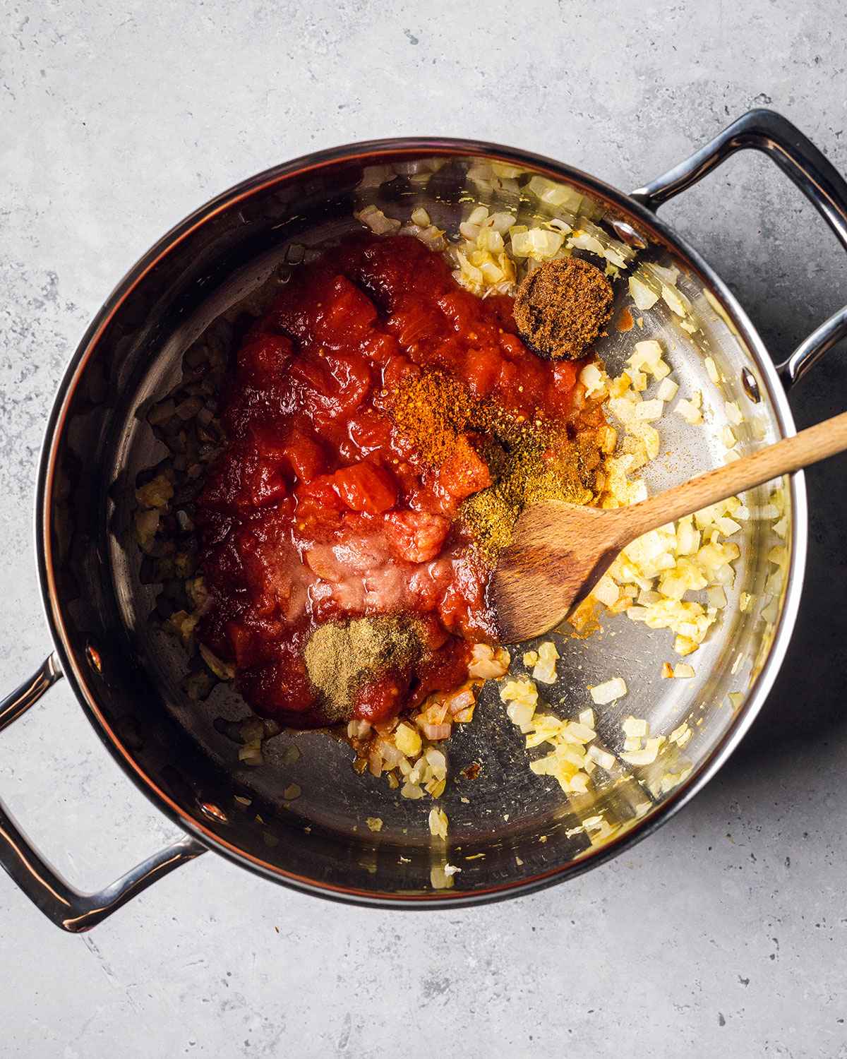 chopped tomatoes and seasonings added to the saucepan