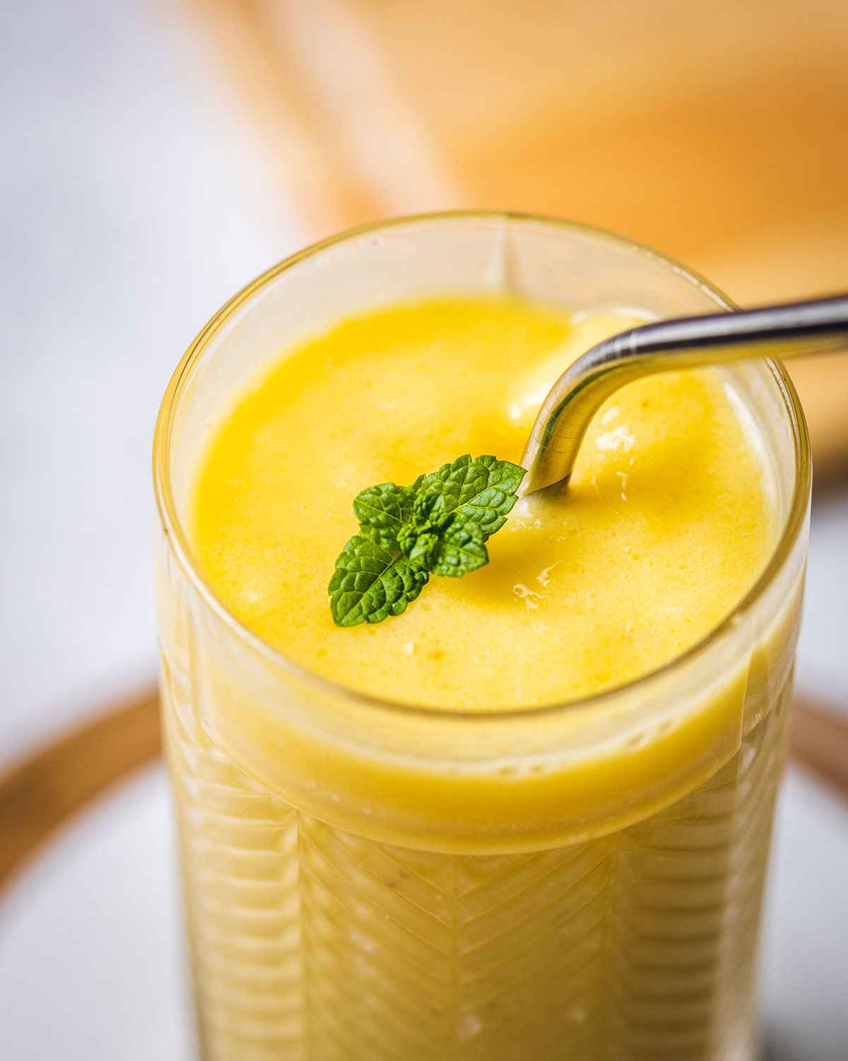 close up of a mango smoothie in a glass