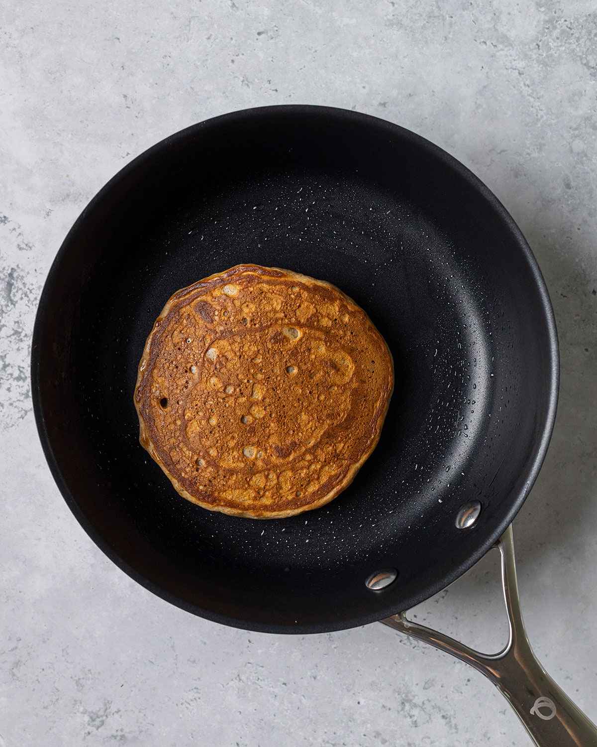 flipped vegan banana pancakes in a skillet