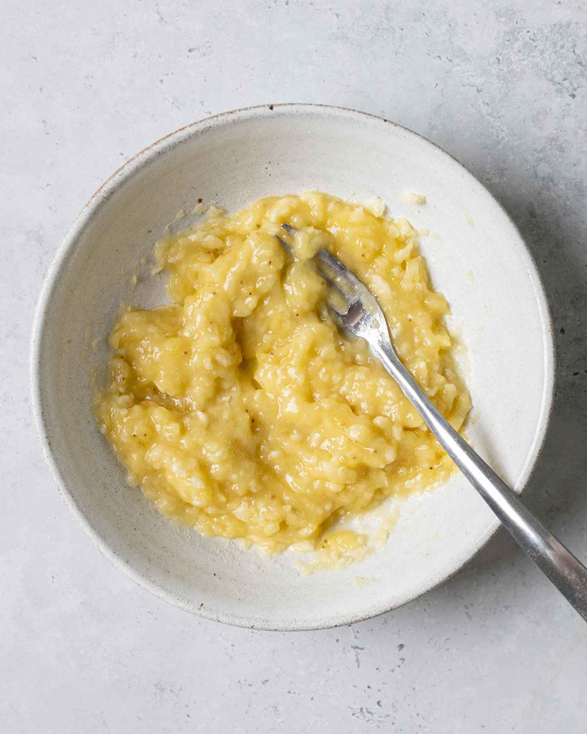 mashed banana in a white bowl