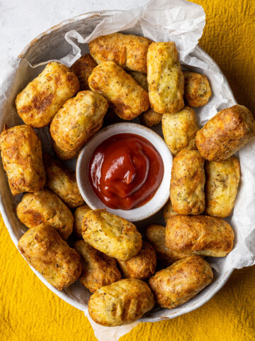 homemade air fryer tater tots in a white bowl with ketchup in the middle