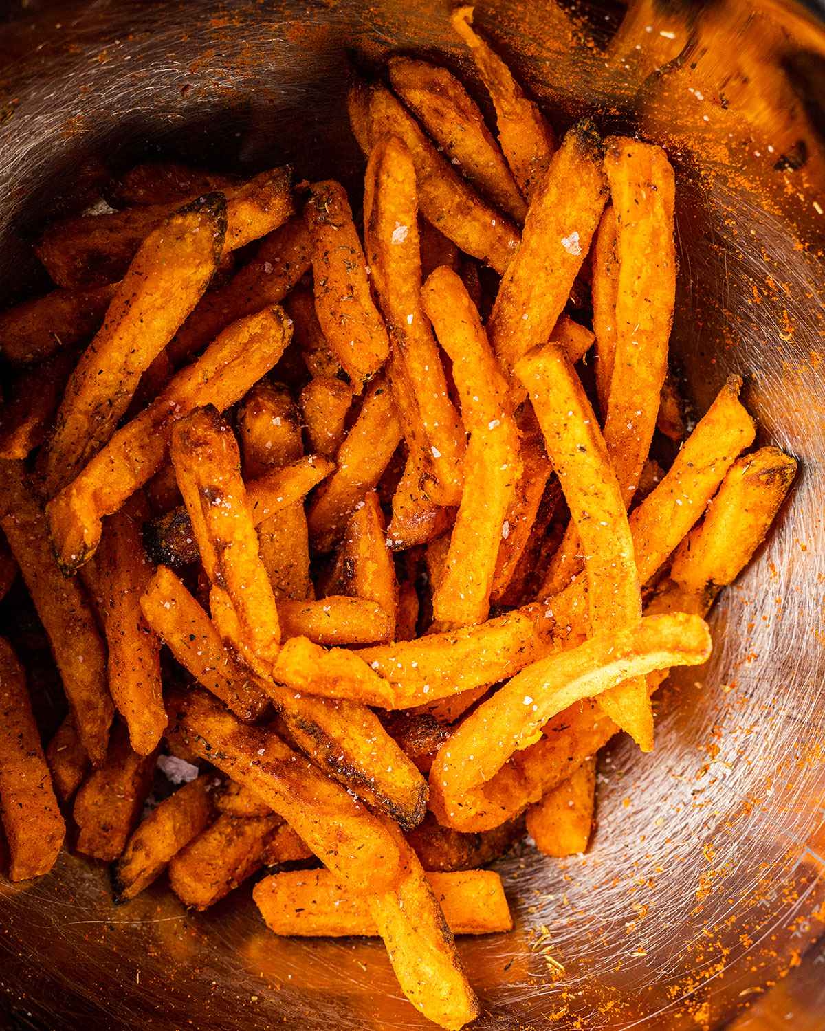 cooked sweet potato fries and seasoning in a bowl