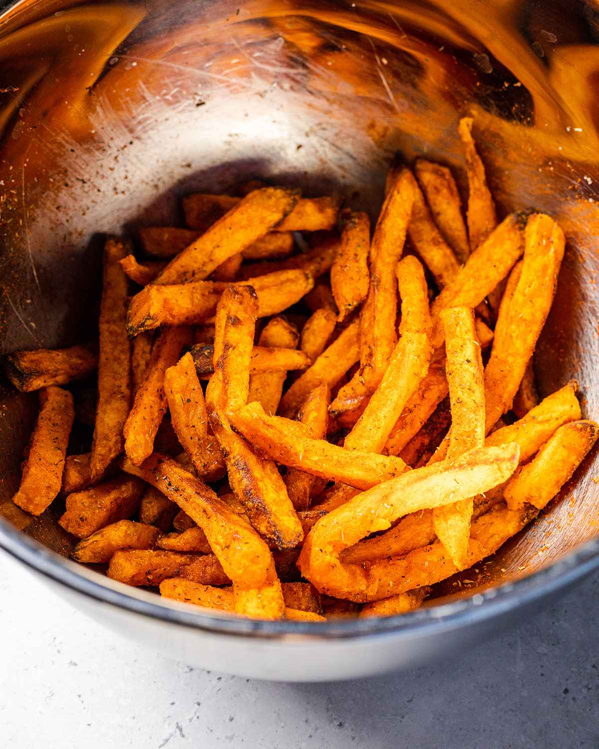 cooked sweet potato fries and seasoning in a bowl