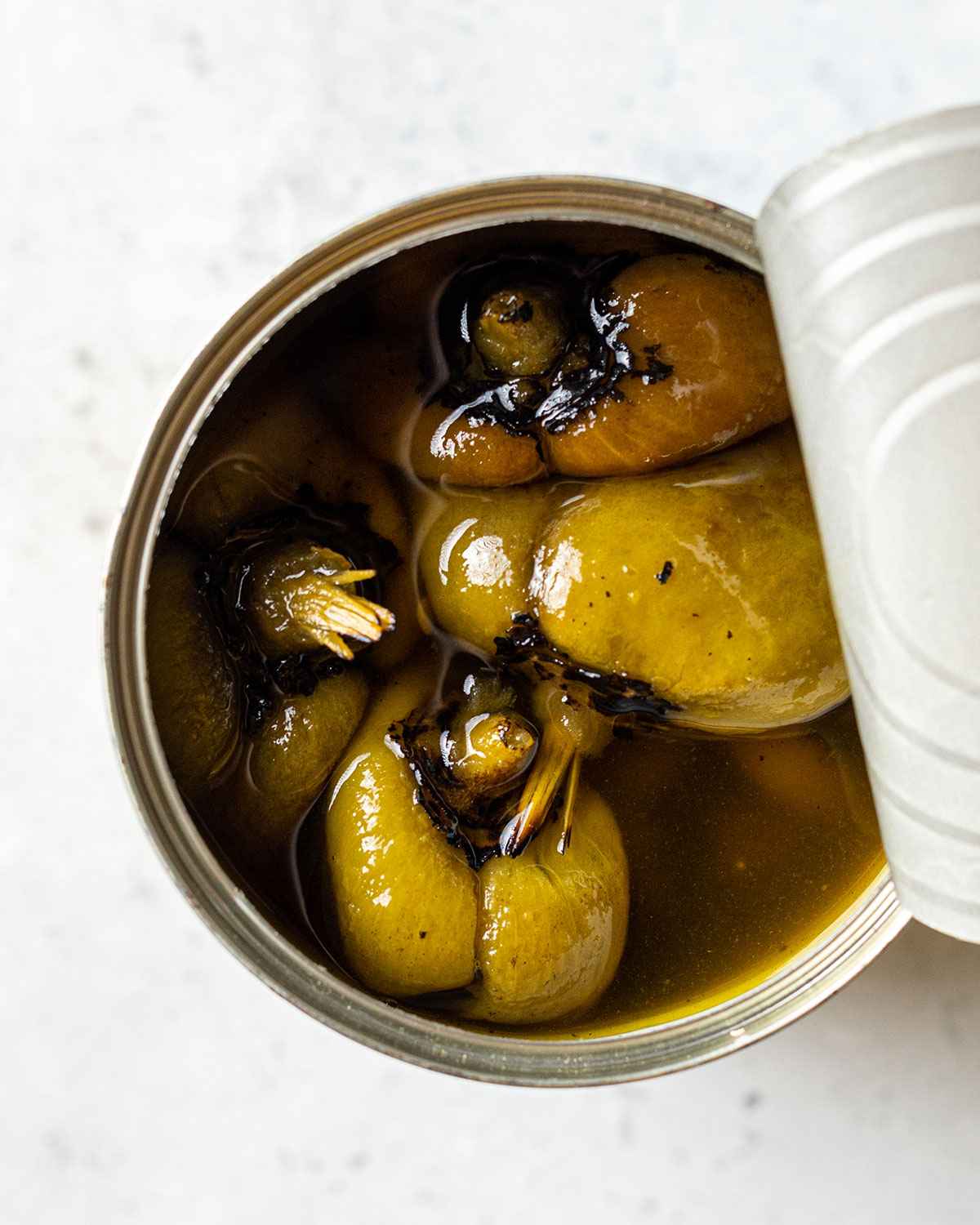 an open tin showing the cooked poblano peppers inside