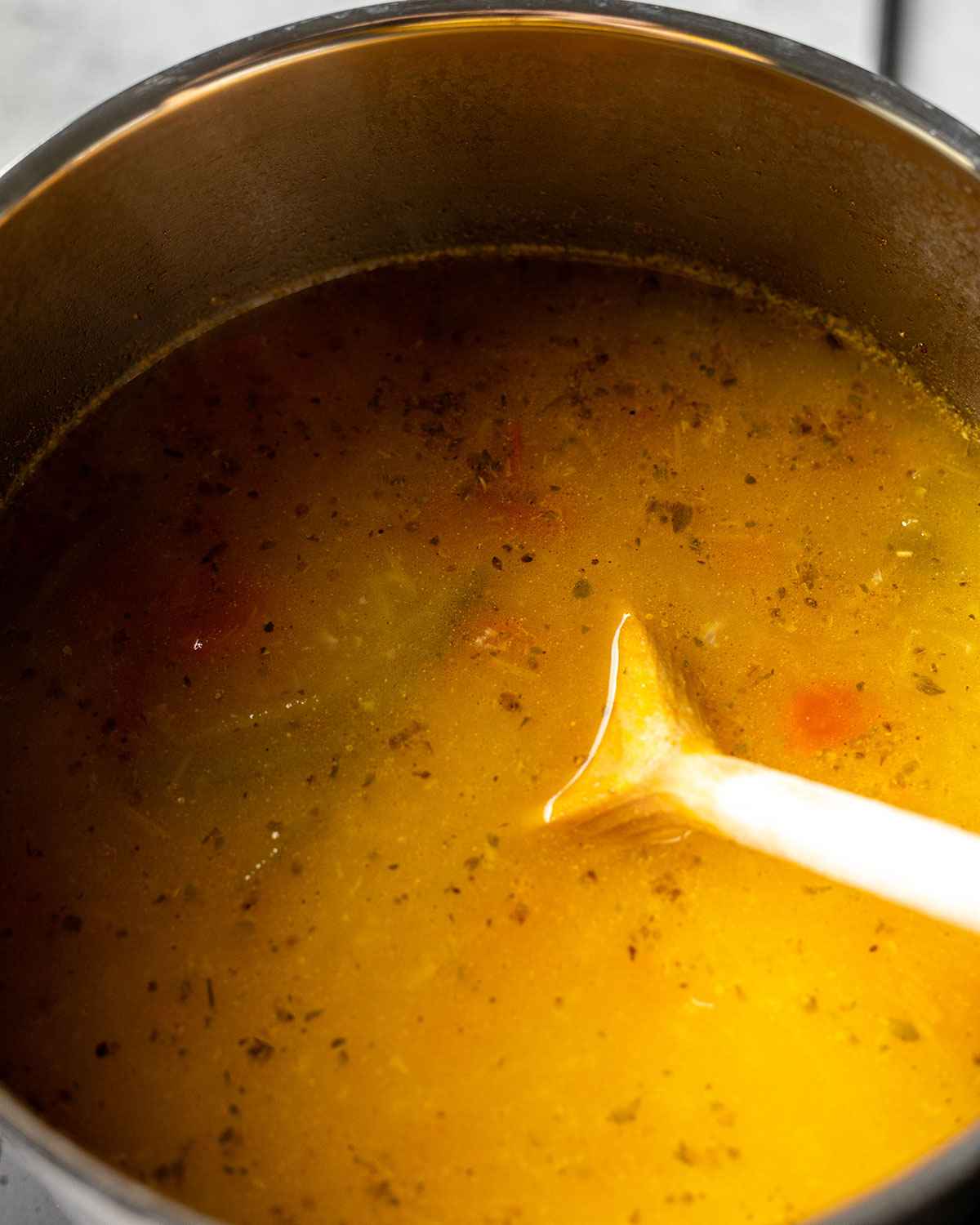 close up of the finished soup in a saucepan with a cooking spoon