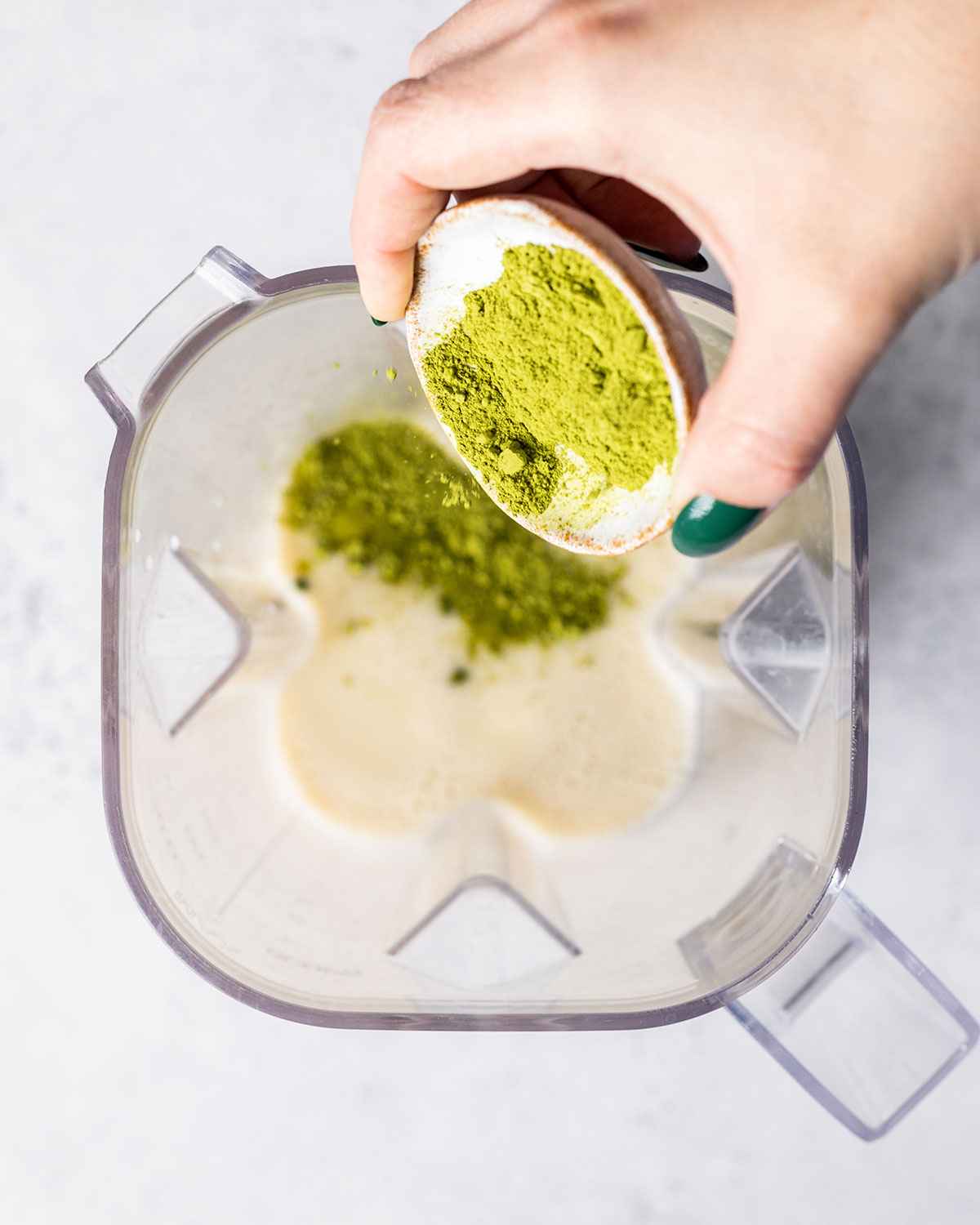 matcha green tea powder being added to a blender