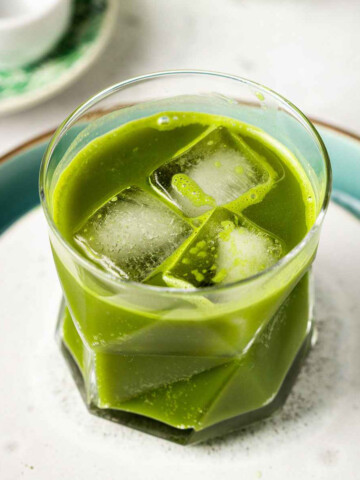 a glass filled with ice cubes and Starbucks-style matcha lemonade