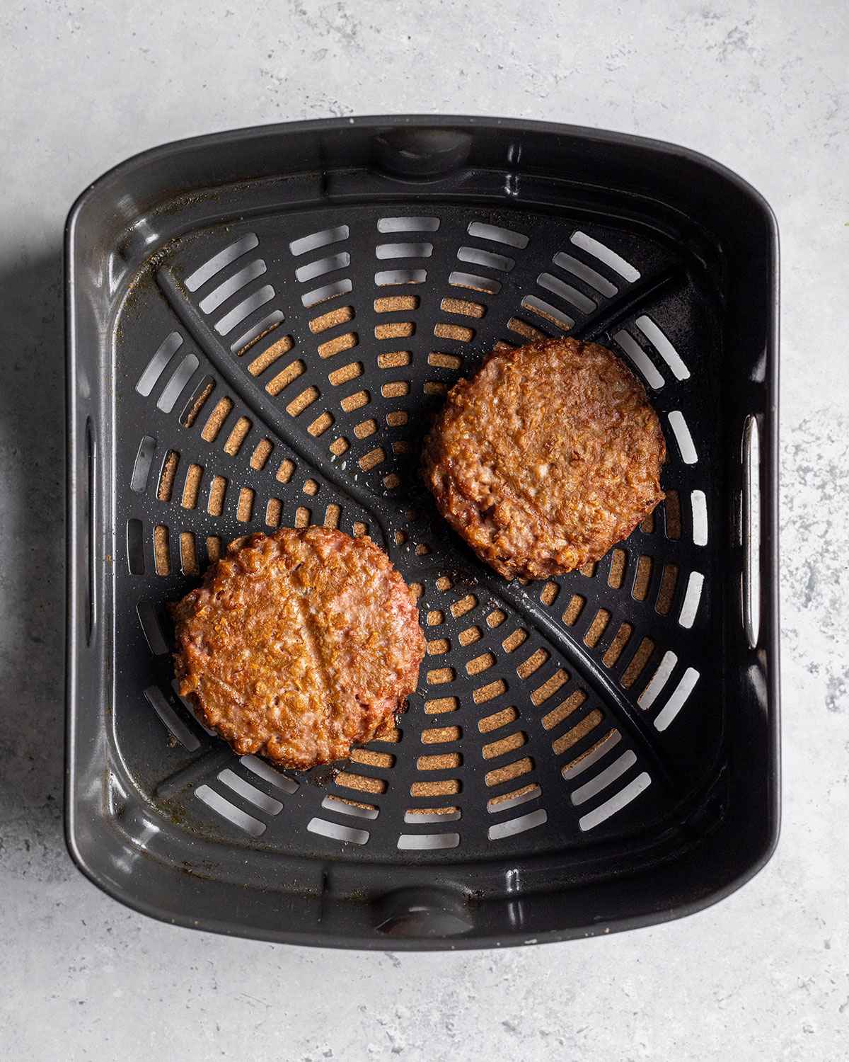 2 beyond meat burgers in an air fryer basket