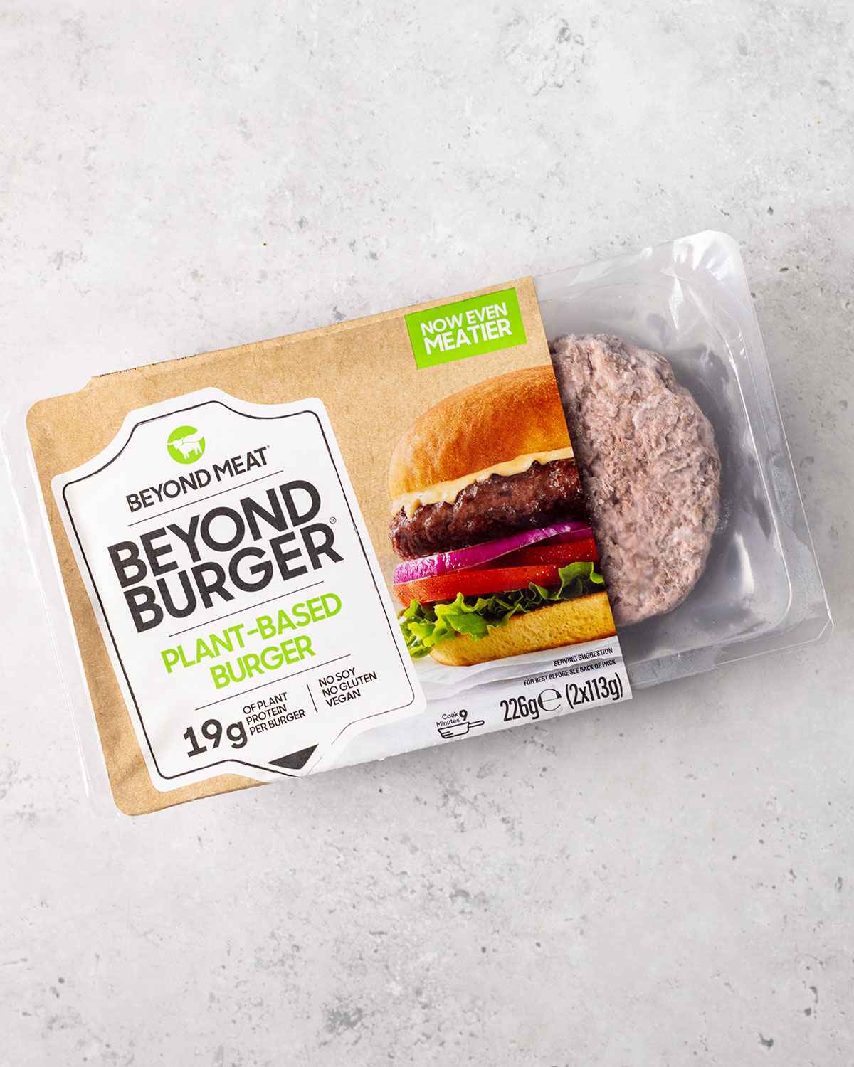 a pack of frozen beyond meat burgers on a white marble table