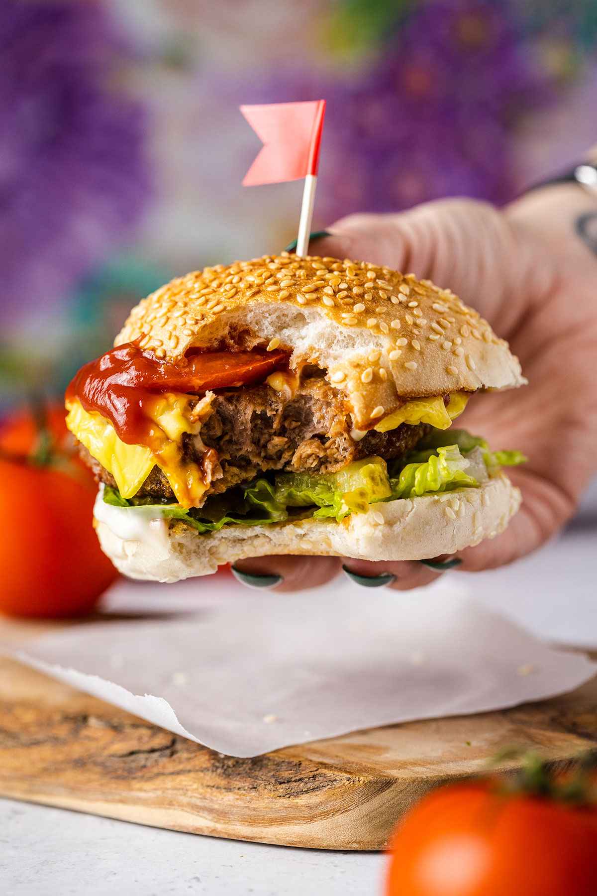 a hand holding an air fryer burger with a bite taken out of it