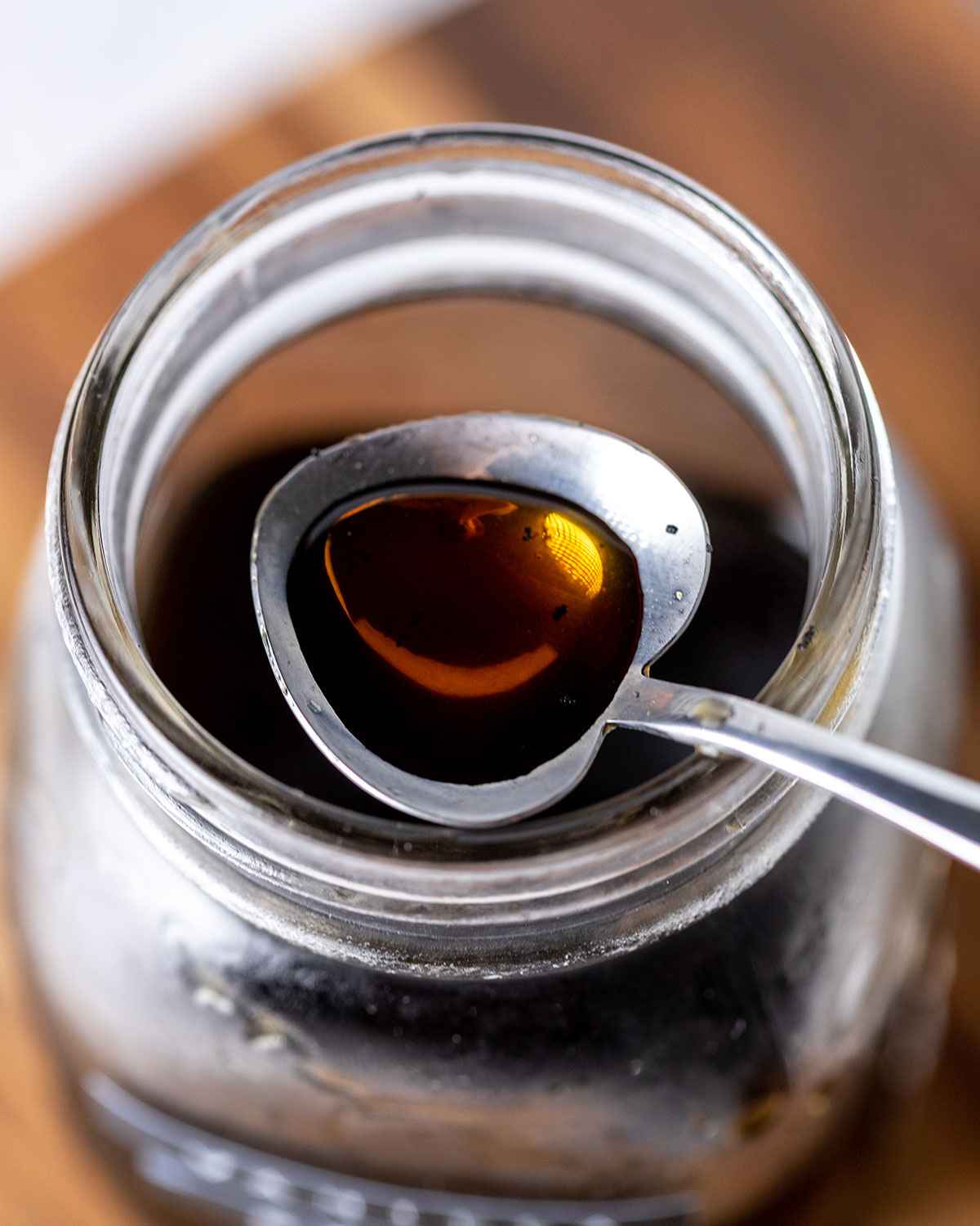 a spoon on top of a jar of vanilla coffee syrup