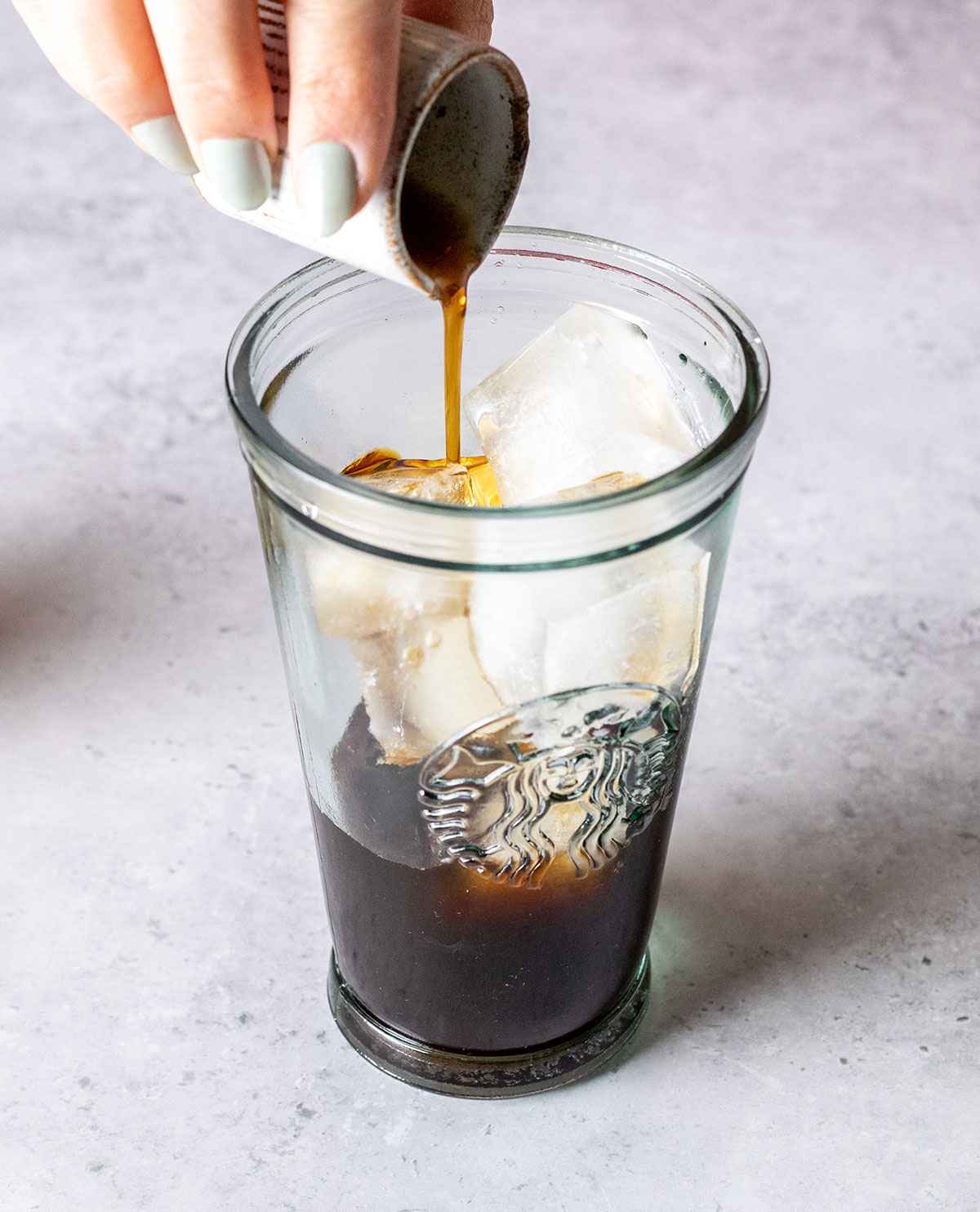 pouring vanilla syrup into a large jar