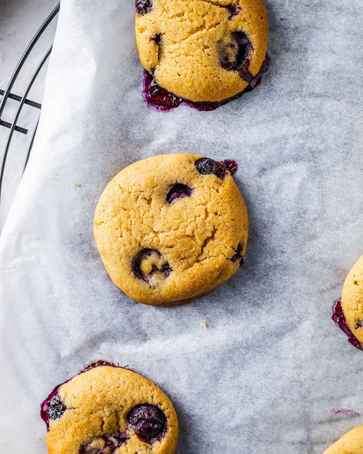Freshly baked blueberry lemon cookies on a cooling rack