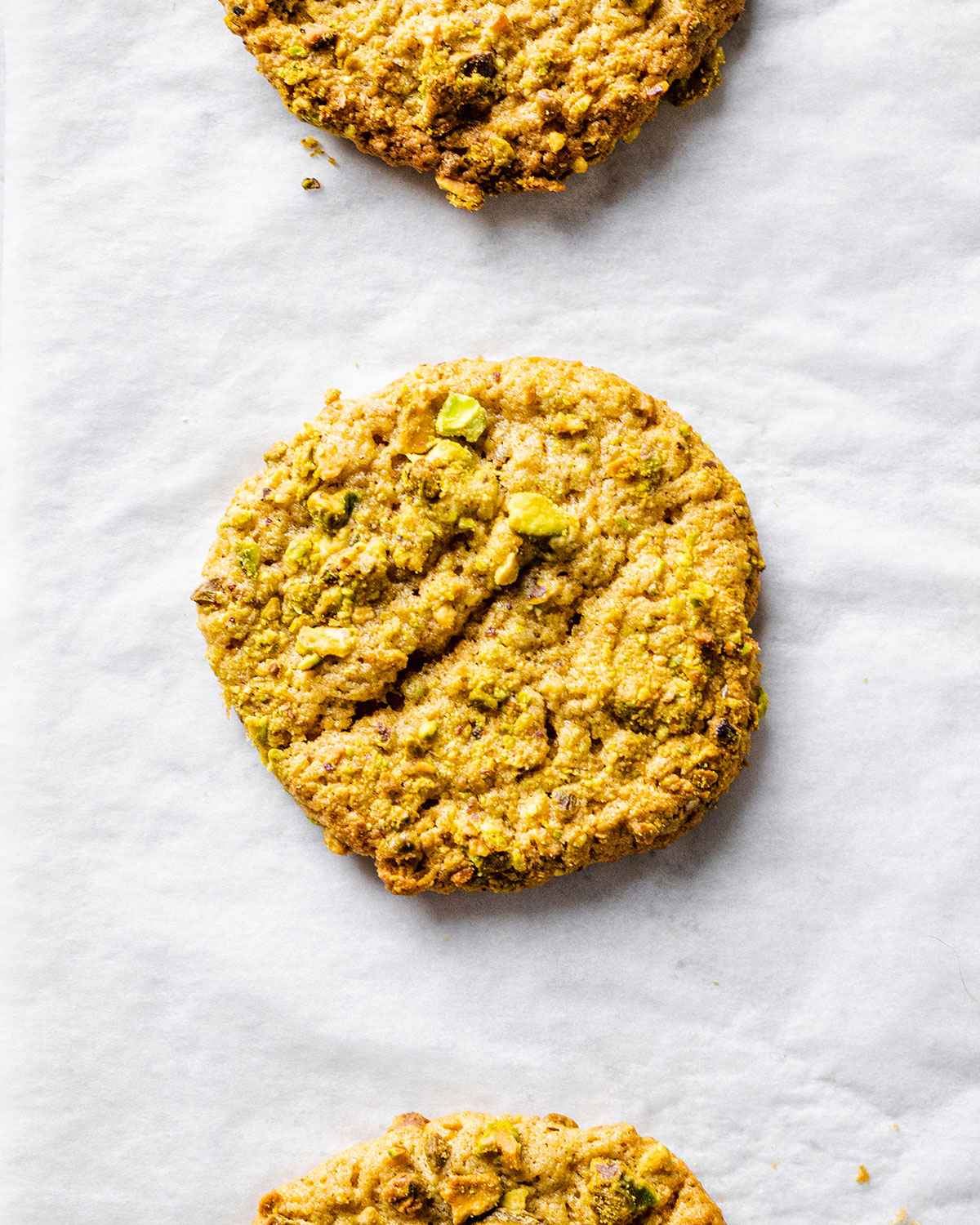 Freshly baked pistachio cookie on a parchment paper.