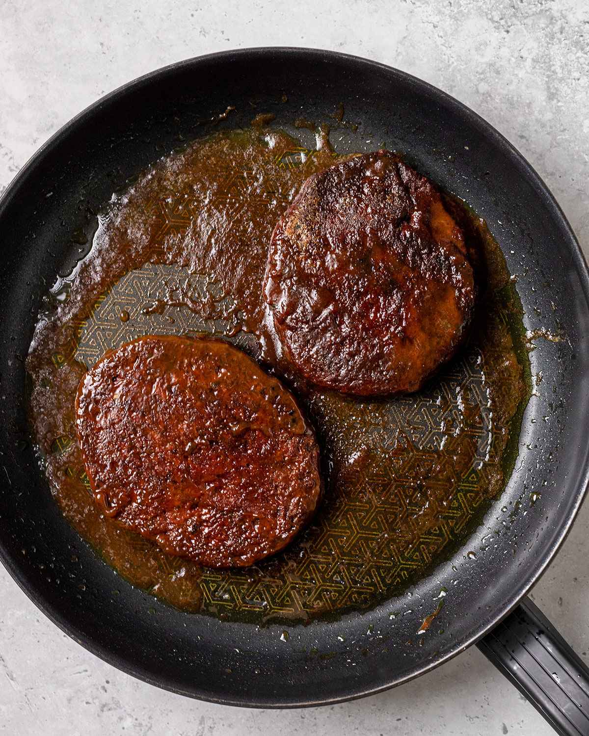 two cooked seitan steaks in a skillet