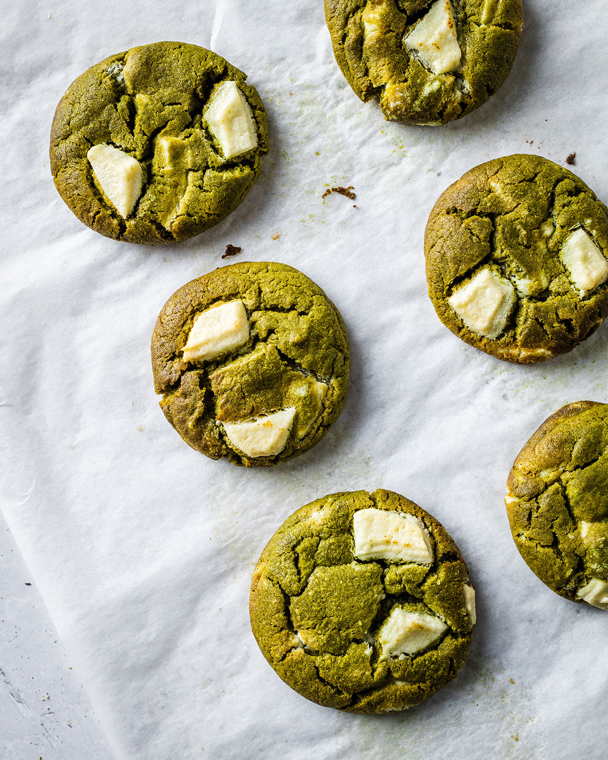 Baked matcha white chocolate cookies straight out of the oven on a baking sheet