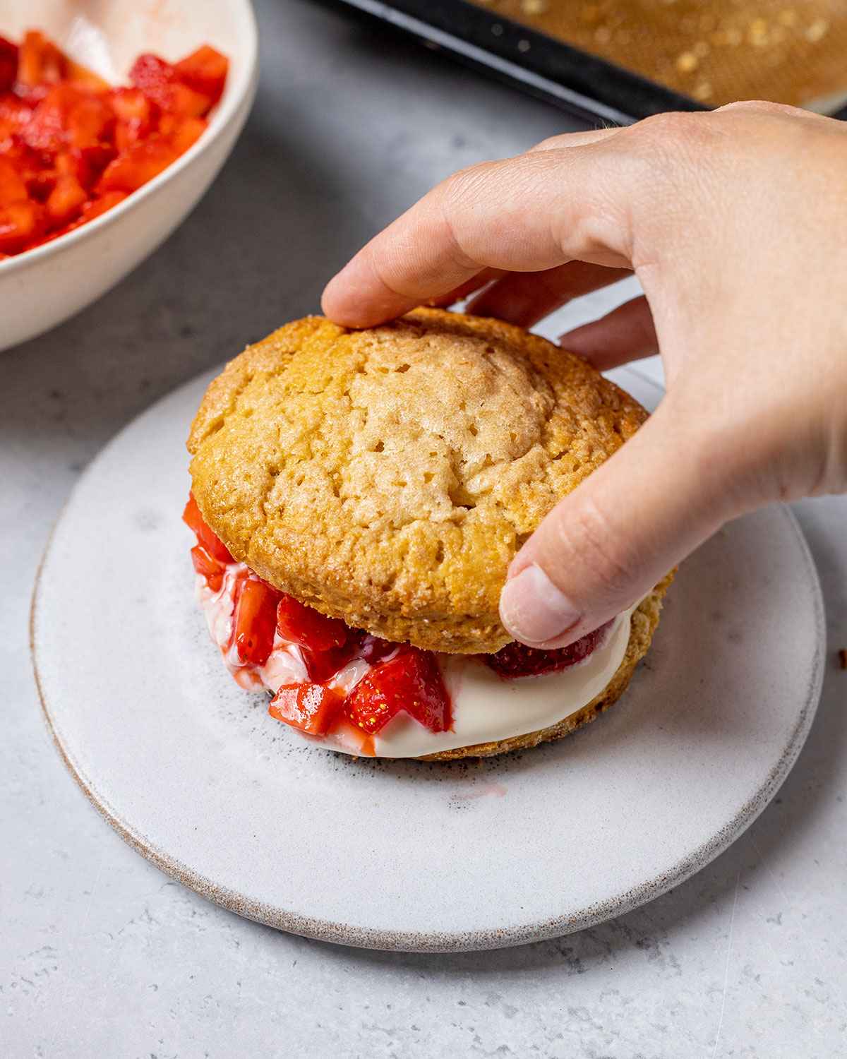 placing the top of a vegan shortcake onto the filling