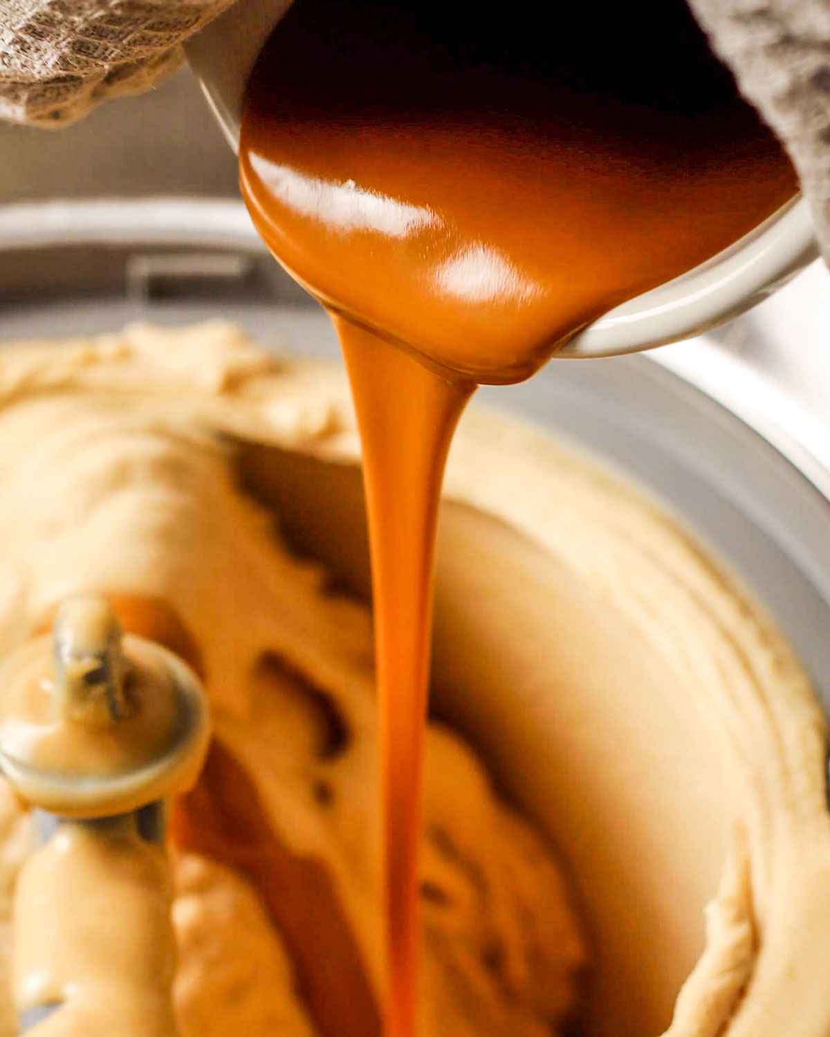 drizzling melted biscoff spread into the ice cream maker