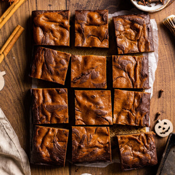 Thumbnail for vegan pumpkin brownies photographed as a flatlay on a wooden table, cut into pieces