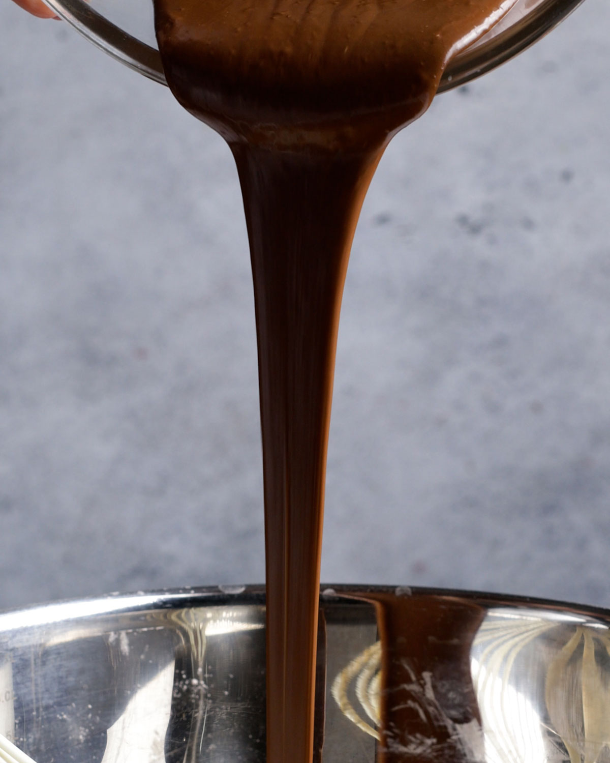 melted chocolate being poured into a mixing bowl