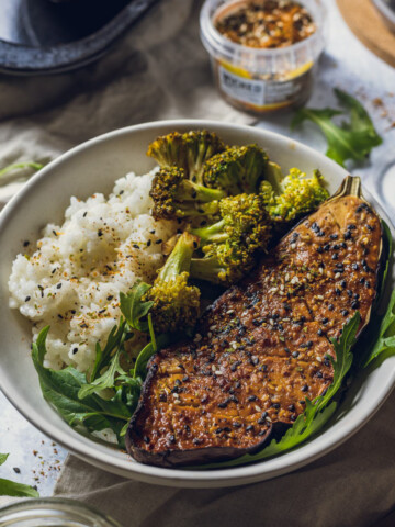 vegan miso aubergine roasted on a serving plate, served with rice and broccoli