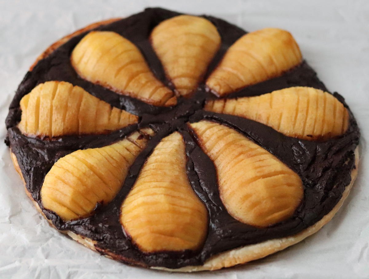 vegan chocolate and pear tart with pear halves neatly arranged on top