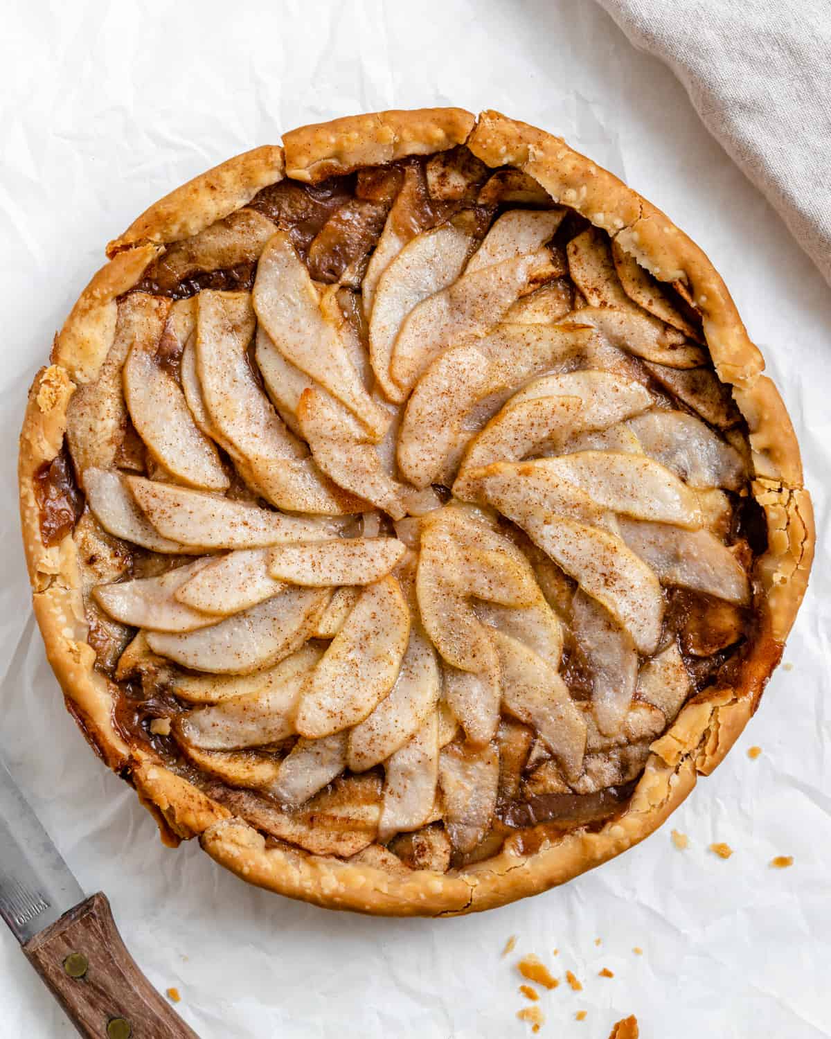 a round vegan apple pear pie as seen from above with fruit slices neatly decorated on top of the vegan pie