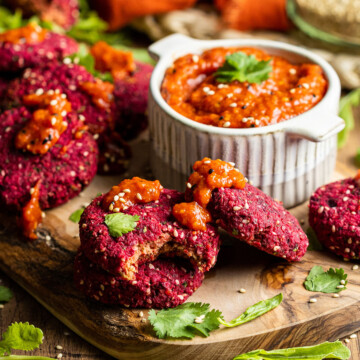 a few vegan beetroot falafels on a board with harissa