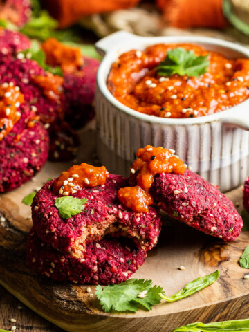 a few vegan beetroot falafels on a board with harissa