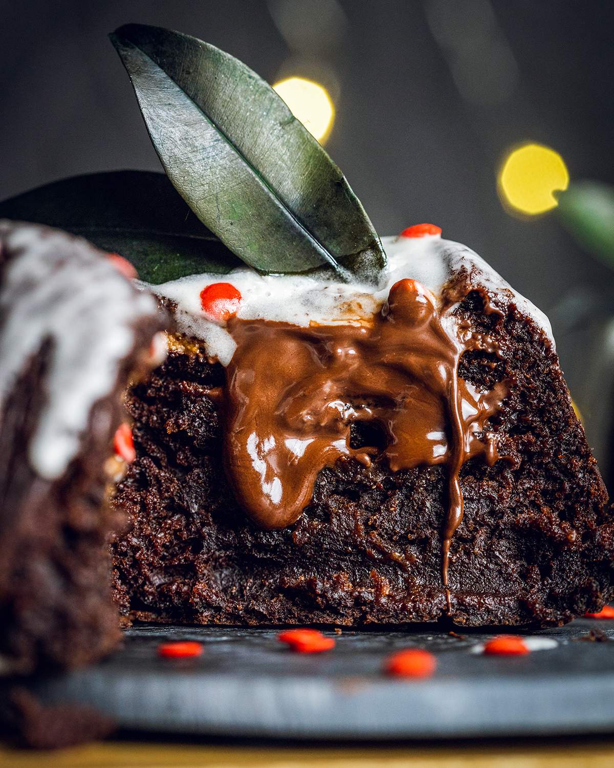 vegan chocolate fondant on a dark plate cut in half with melted chocolate inside