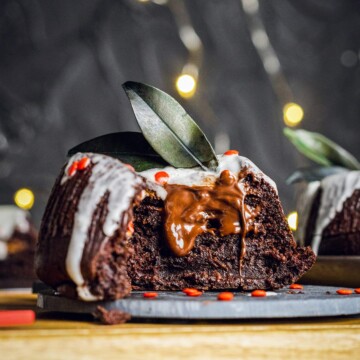 vegan chocolate fondant on a dark plate cut in half with melted chocolate inside