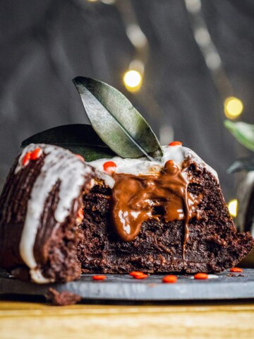 vegan chocolate fondant on a dark plate cut in half with melted chocolate inside