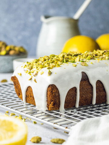 vegan pistachio loaf cake with cardamom and white icing on top