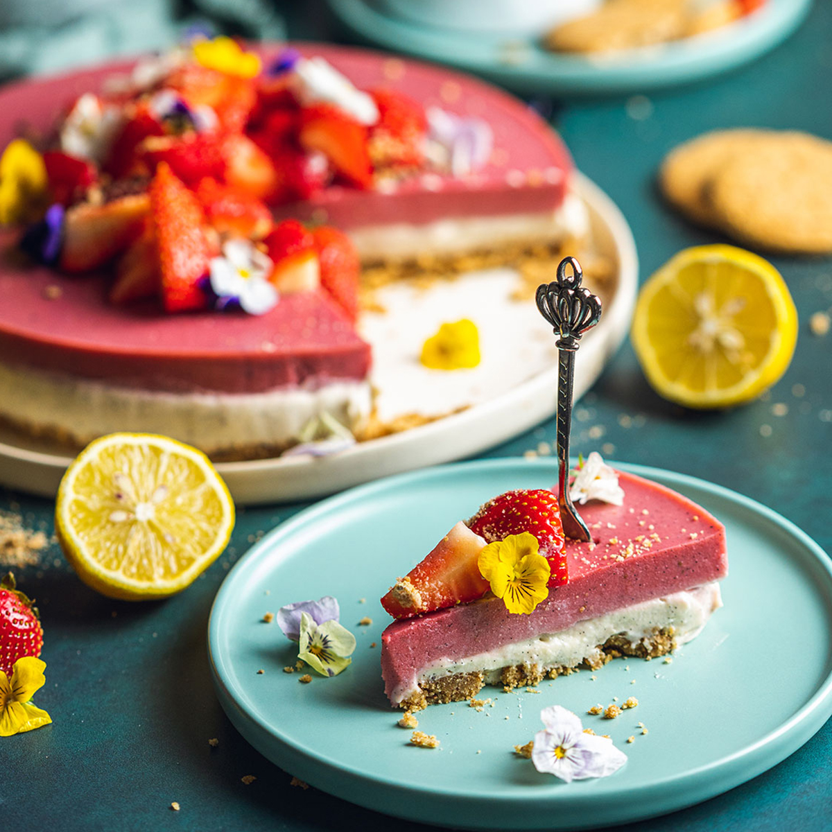 a slice of vegan strawberry cheesecake on a blue plate with the rest of the cake in the background