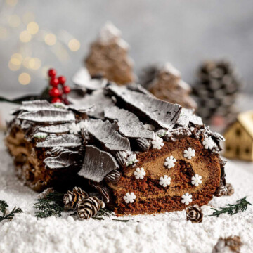 a chocolate yule log cake covered with icing sugar to look like snow