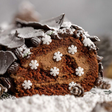 Vegan Yule Log with Chocolate bark sprinkled in icing sugar