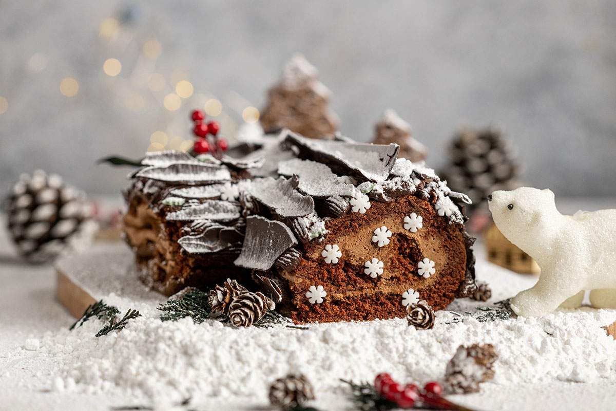 Vegan Yule Log with Chocolate bark sprinkled in icing sugar