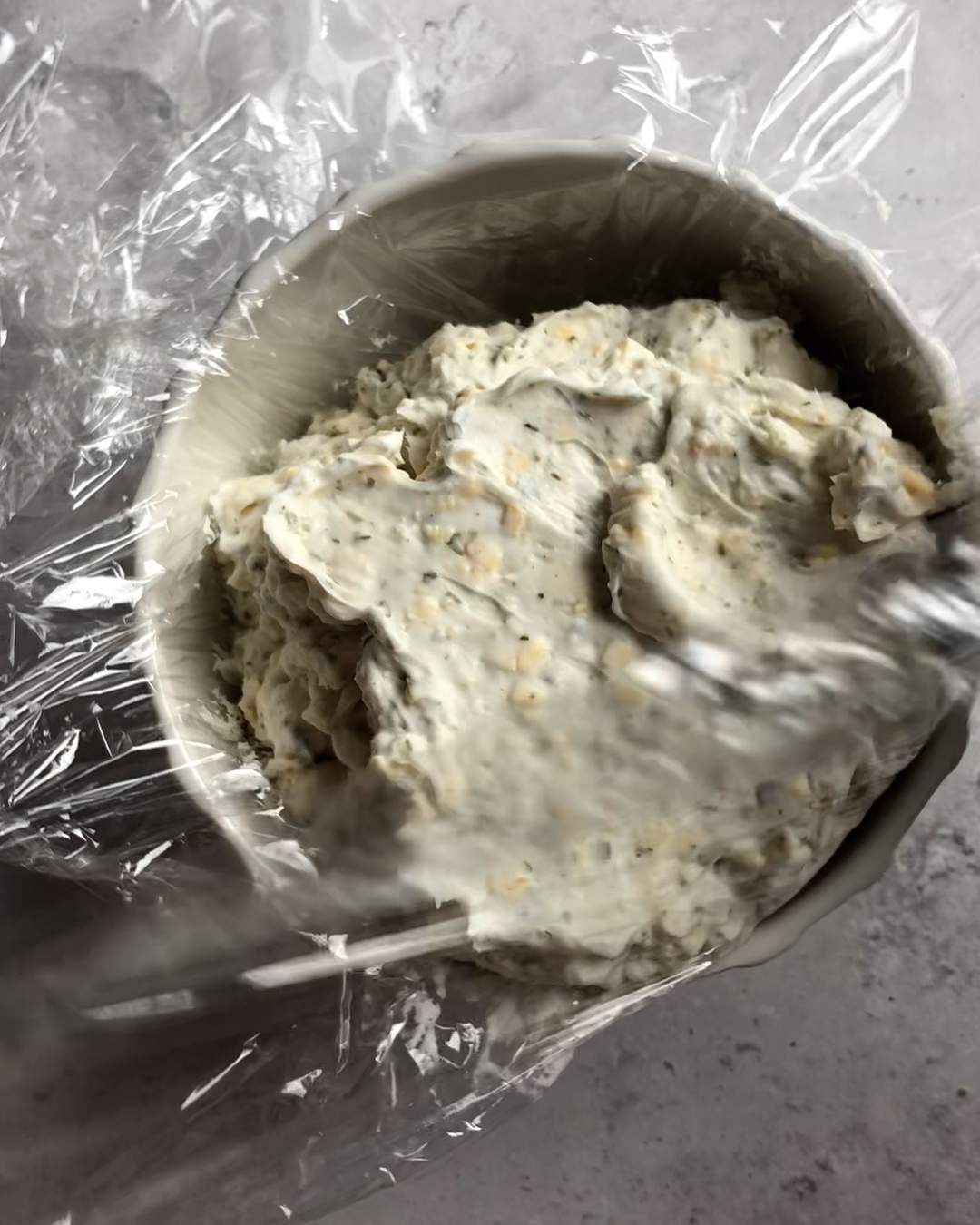 cream cheese mixture transferred to a bowl lined with plastic wrap