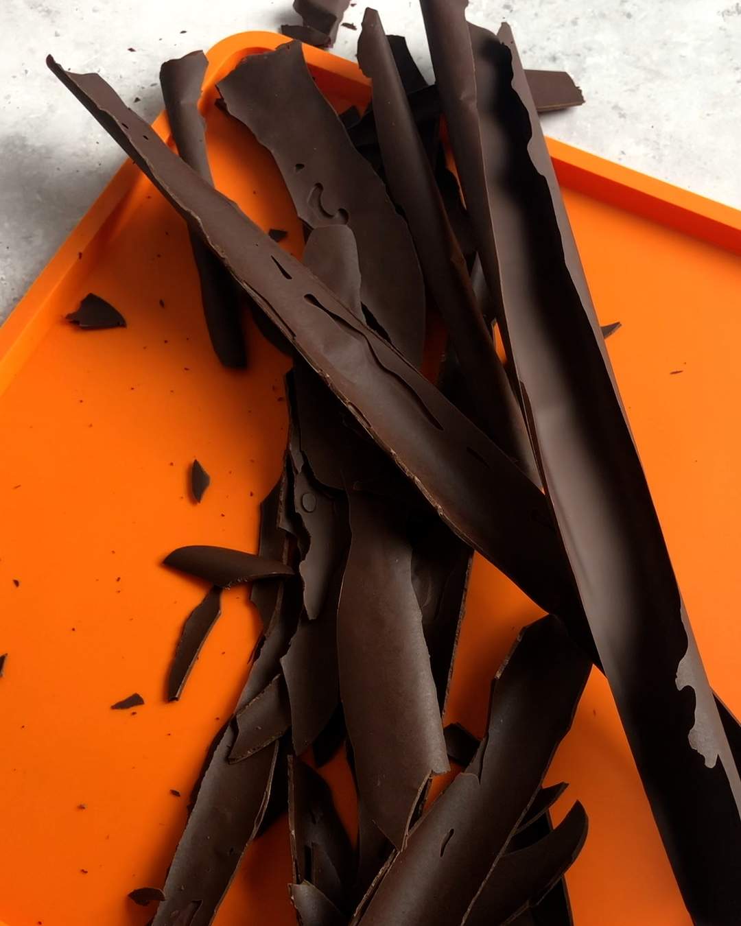 dark chocolate bark pieces on a silicone mat